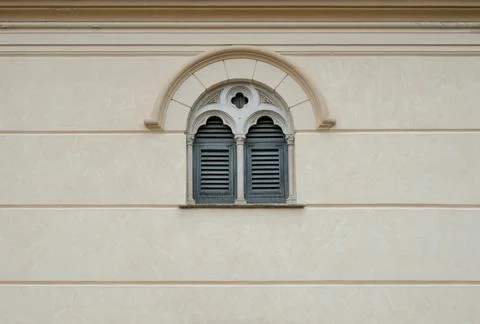 Baroque window framing and figured details around the arch on facade wall Fotos Stock