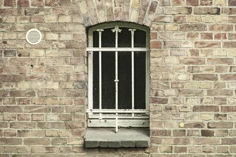 Barred cellar window in a brick wall Stock Photos