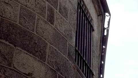 Barred window and rusted rain gutter on prison building at Eastern State Stock Footage 163396334