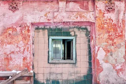 A barred window in the old brick wall of an abandoned industrial building. Stock Photos