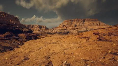 Barren desert landscape under a dramatic sky with rugged cliffs in view Stock Illustration