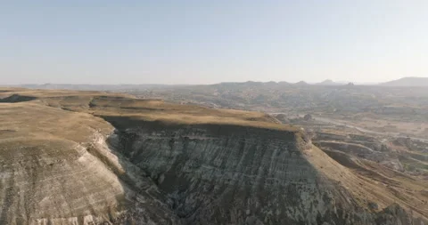 Barren landscape from above: Canyon with distant mountains, Cappadocia, Turkiye Video stock 251990488