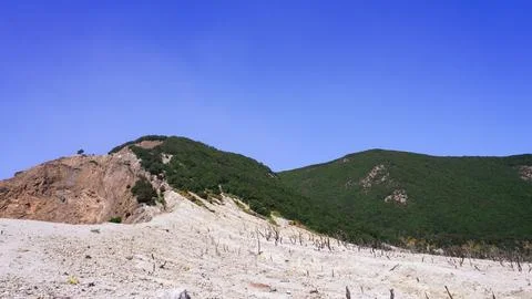 Barren mountain landscape with sparse vegetation under a clear blue sky. Id.. Stock Photos