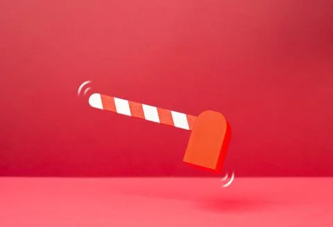 A barrier gate on a red background. Concept of control and checkpoint access. Stock Photos