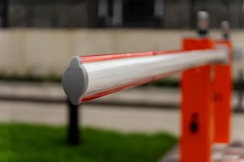 A barrier gate stands closed, regulating access to a controlled area in a c.. 库存照片