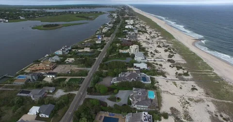 Barrier island homes between a calm bay and broad ocean beach Vídeos de archivo 59523186