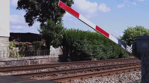 The barrier on the railway lowers in front of the train. Stock Footage 134123338