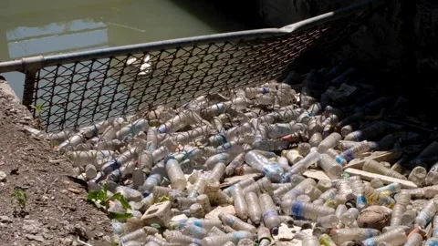 Barrier stopping plastic bottles and other trash and rubbish flowing into ocean Stock Footage 337963625