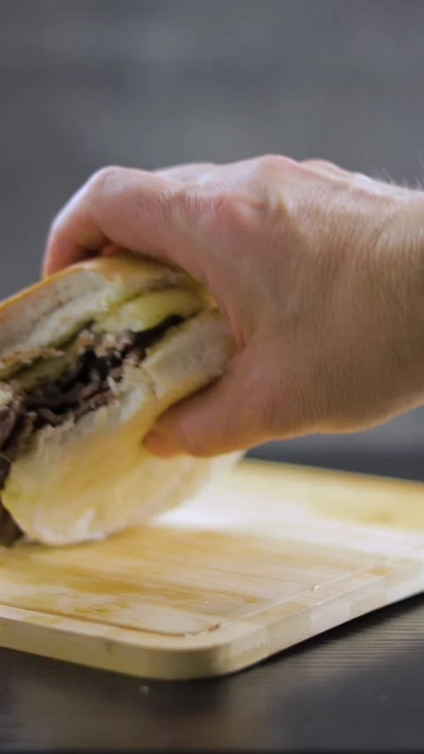 Barros Luco bitten: beef with melted cheese. Hand placing the sandwich on b.. Stock Footage 242655258
