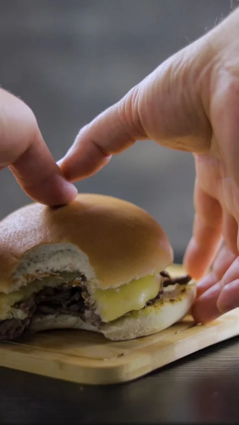 Barros Luco bitten: beef with melted cheese. Hands taking the sandwich on b.. Stock Footage 242655261
