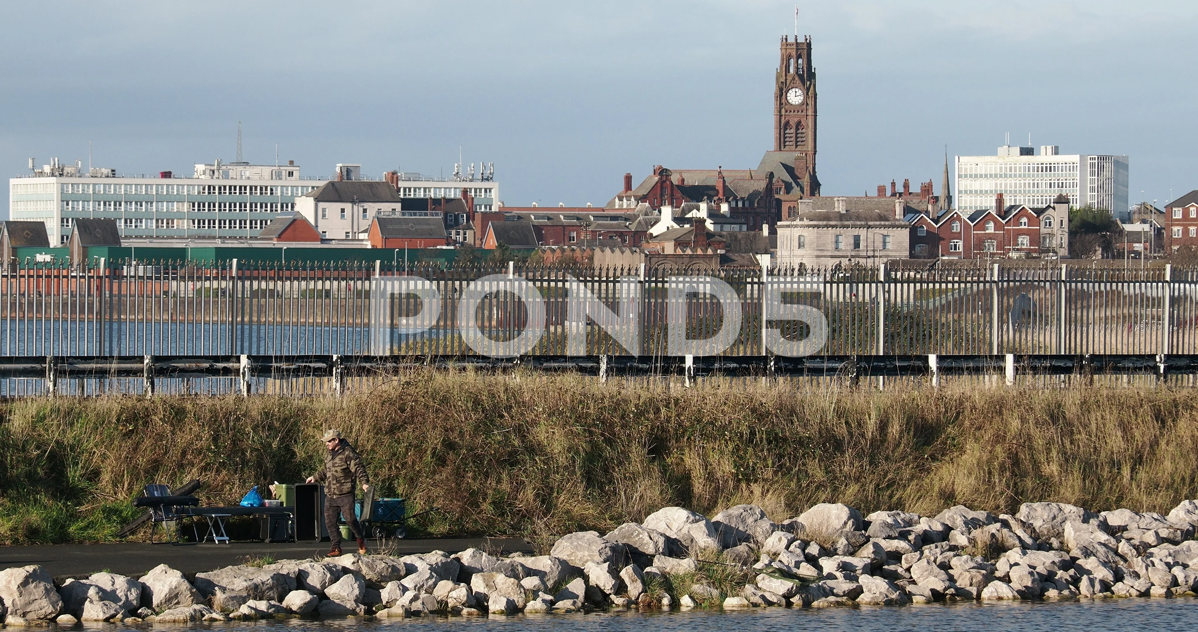 Barrow in Furness town hall and a man fishing in the docks Cumbria UK