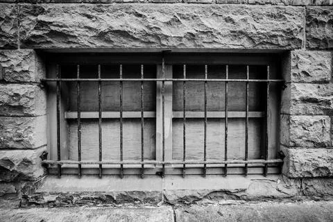 Bars over boarded up basement window Fotos Stock