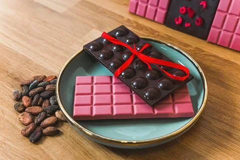 Bars of ruby and dark chocolate artfully arrenged on blue plate. Premium 写真素材