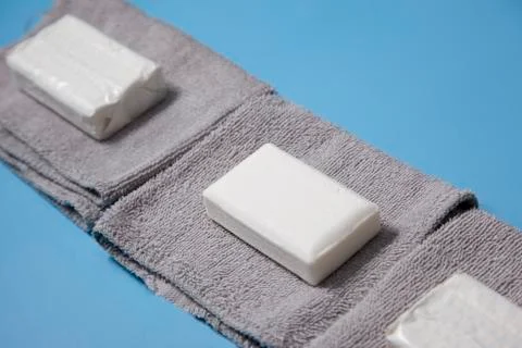 Bars of soap sitting on grey face cloths Stock Photos