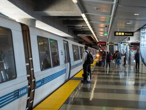 BART bay area rapid transit train with passengers boarding at SFO stop Stock Photos
