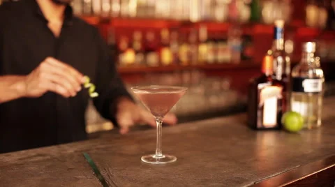 Bartender adding finishing touch to cosmopolitan Stock Footage 63306042