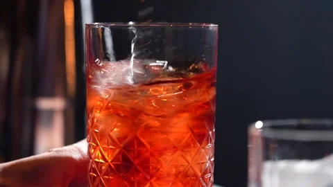 Bartender adding ice cubes and stirring in cocktail glass making cocktail Stock Footage 149240304