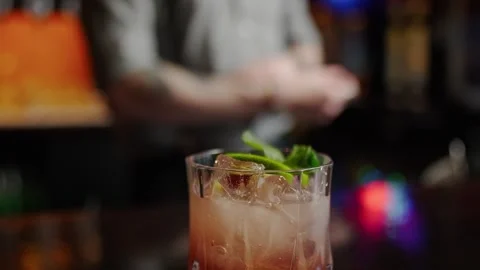 A bartender is adding a lime on top of an alcohol cocktail Stock Footage 301412166