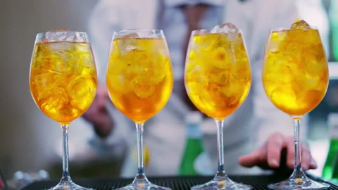 Bartender adding orange fruit pieces to Aperol Spritz cocktail at the bar Stock Footage 317581417