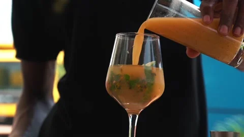 Bartender adding passion fruit juice to a glass, making a mojito cocktail Stock Footage 230080295