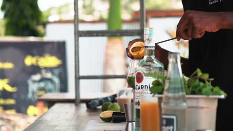 Bartender adding passion fruit juice to a glass, making a mojito cocktail Video stock 230080384