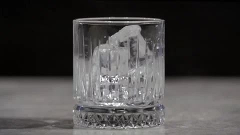 The bartender adds ice to a glass on the table. Glass for alcohol. Stock Footage 219564417