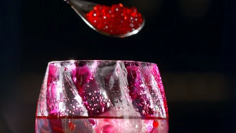 Bartender adds molecular caviar to glasses  cocktail with ice and drops on glass Stock Footage 129478280
