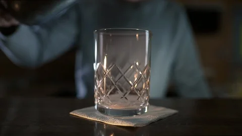 Bartender adds some ice to the glass before making cocktail, alcohol drink Stock Footage 105925326