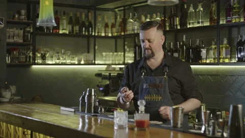The bartender aesthetically warms the cocktail before serving it to the client. Video stock 236538156