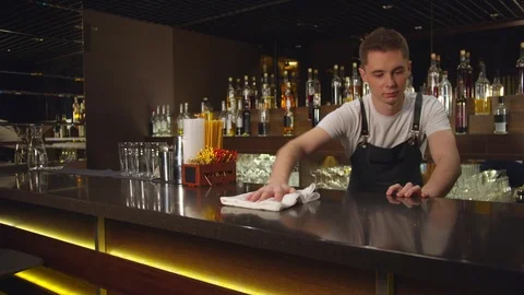Bartender in the apron wipes bar counter with a rag Stock Footage 123679573