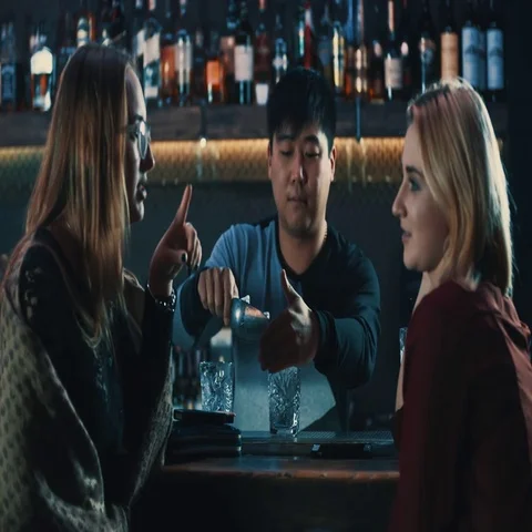 Bartender barman making cocktails for two girls at bar counter 4k video. Stock Footage 69377188
