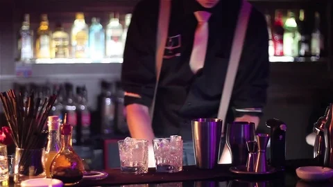 Bartender, barman is making delicious cocktail at bar counter using ice and swee Stock Footage 76471746