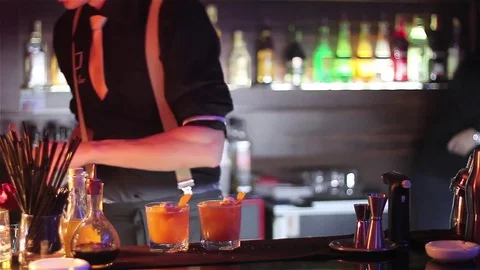 Bartender, barman is making delicious cocktail at bar counter using ice and swee Stock Footage 76471925
