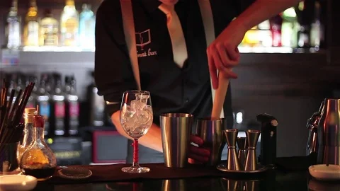 Bartender, barman is making delicious cocktail at bar counter using ice and swee Stock Footage 76471934