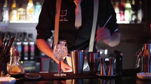 Bartender, barman is making delicious cocktail at bar counter using ice and swee Stock Footage 76472045