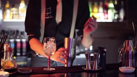 Bartender, barman is making delicious cocktail at bar counter using ice and swee Stock Footage 76472488