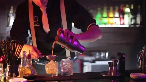 Bartender, barman is making delicious cocktail at bar counter using ice and swee Stock Footage 76472933