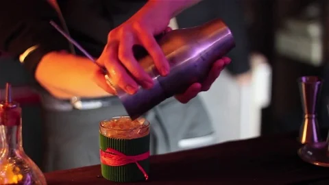 Bartender, barman is making delicious cocktail at bar counter using ice and swee Stock Footage 76473150