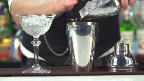 Bartender, barman is making delicious cocktail at bar counter using ice and swee Stock Footage 76473242