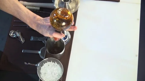 Bartender, barman is making delicious cocktail at bar counter using ice and swee Stock Footage 76473312