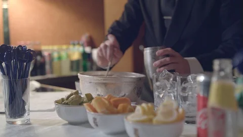 A bartender in a black jacket puts ice from a fogged vat into a metal shaker Stock Footage 128427896