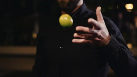 Bartender in black shirt throws a lemon from hand to hand Video stock 144002808