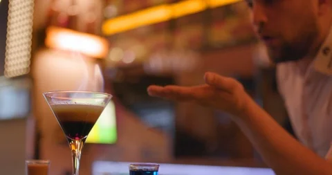Bartender blowing to fire up flame cocktail Stock Footage