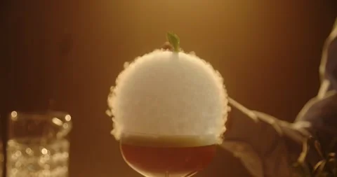 Bartender Bursting Smoke Bubble with Garnish Over Red Cocktail Close Up Stockbeeldmateriaal 347899330