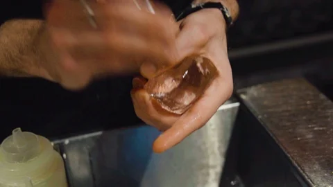 Bartender carves ice cube using ice pick - close up Video stock 127295731