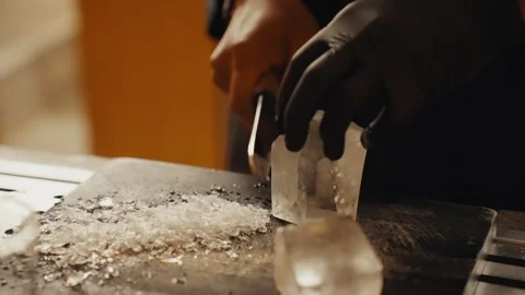 Bartender carving clear ice cube with knife Stock Footage 339806263