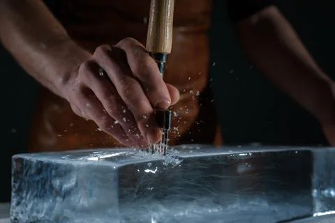Bartender chopping ice using a special knife Stock Photos