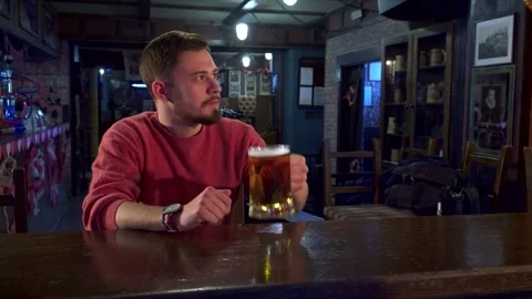 Bartender cleans the counter while a customer enjoys a drink Stock Footage 311944843