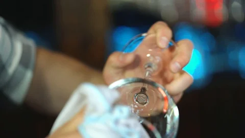 Bartender cleans the glass. Handsome bartender polishes a glass of wine glasses. Stock Footage 90639391
