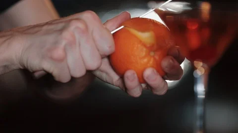Bartender cleans orange for cocktail Video stock 128604195
